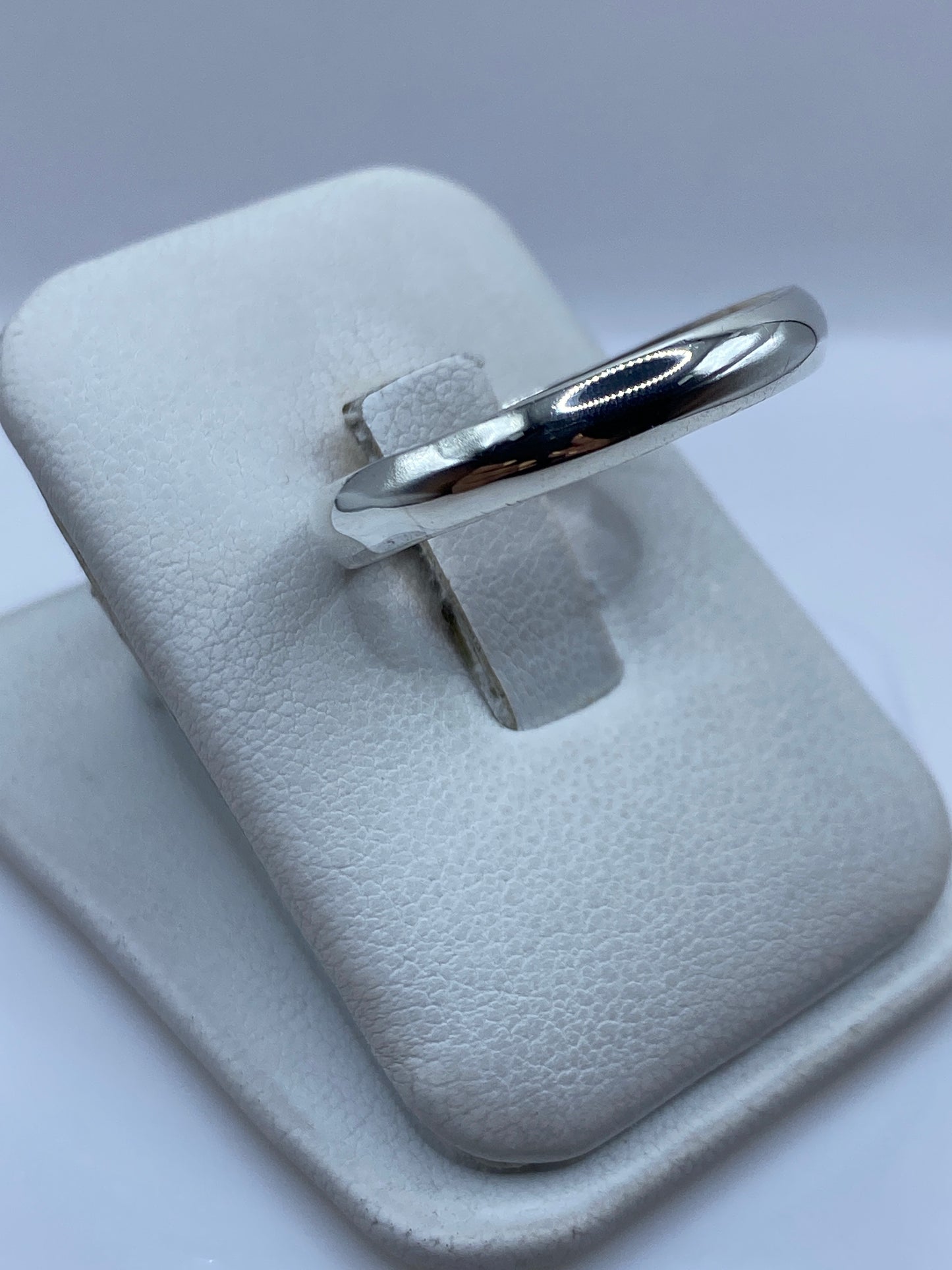 Anillo de plata puro en la mano, mostrando el acabado brillante y el Quinto 925