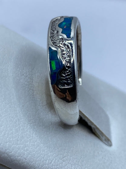 Anillo en el dedo mostrando los reflejos azules y verdes del ópalo