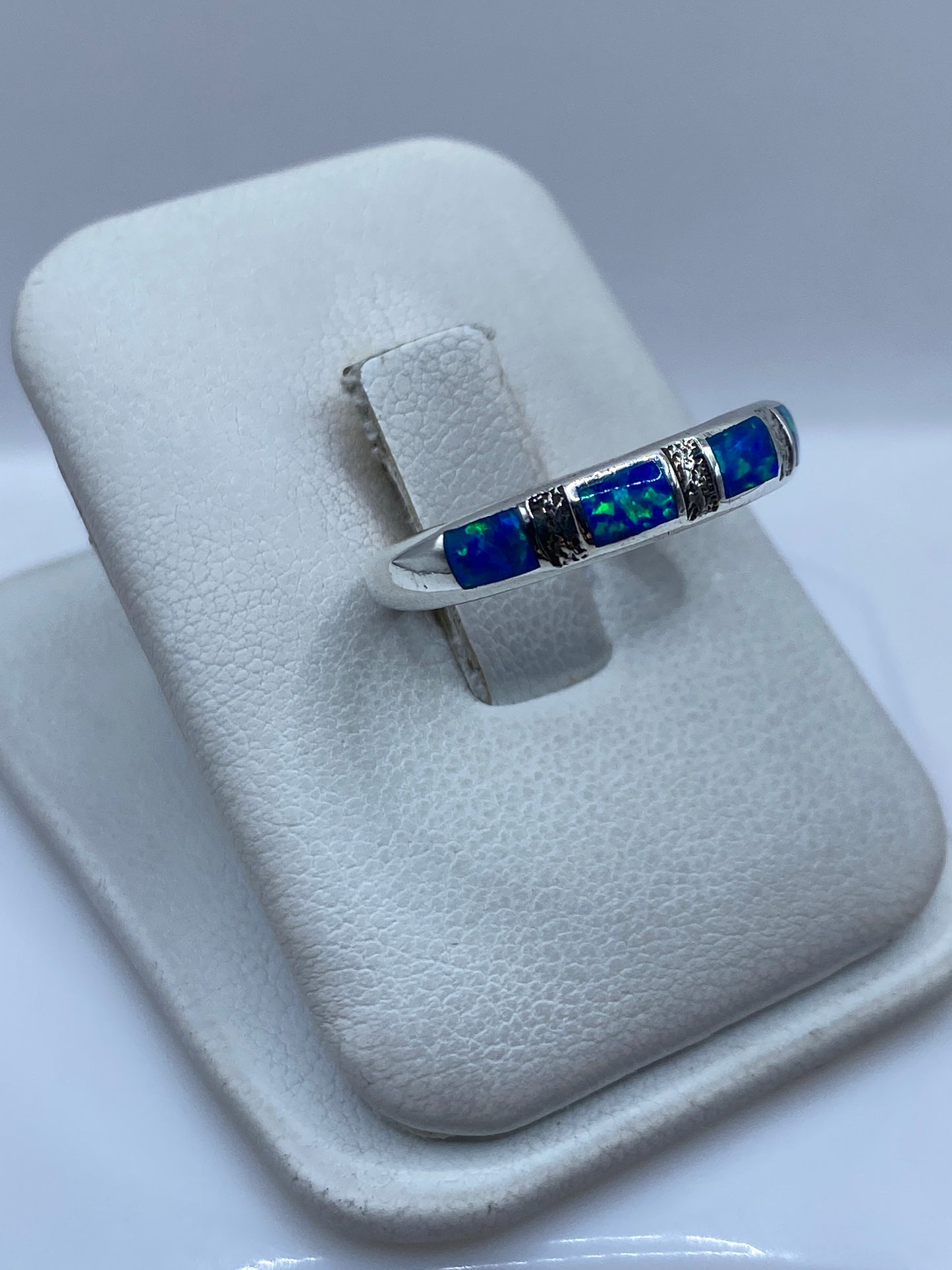 Detalle lateral del anillo mostrando el engaste a mano del ópalo y el pulido de la plata