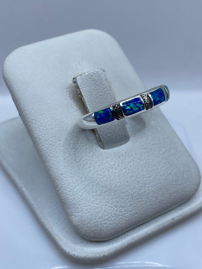 Detalle lateral del anillo mostrando el engaste a mano del ópalo y el pulido de la plata