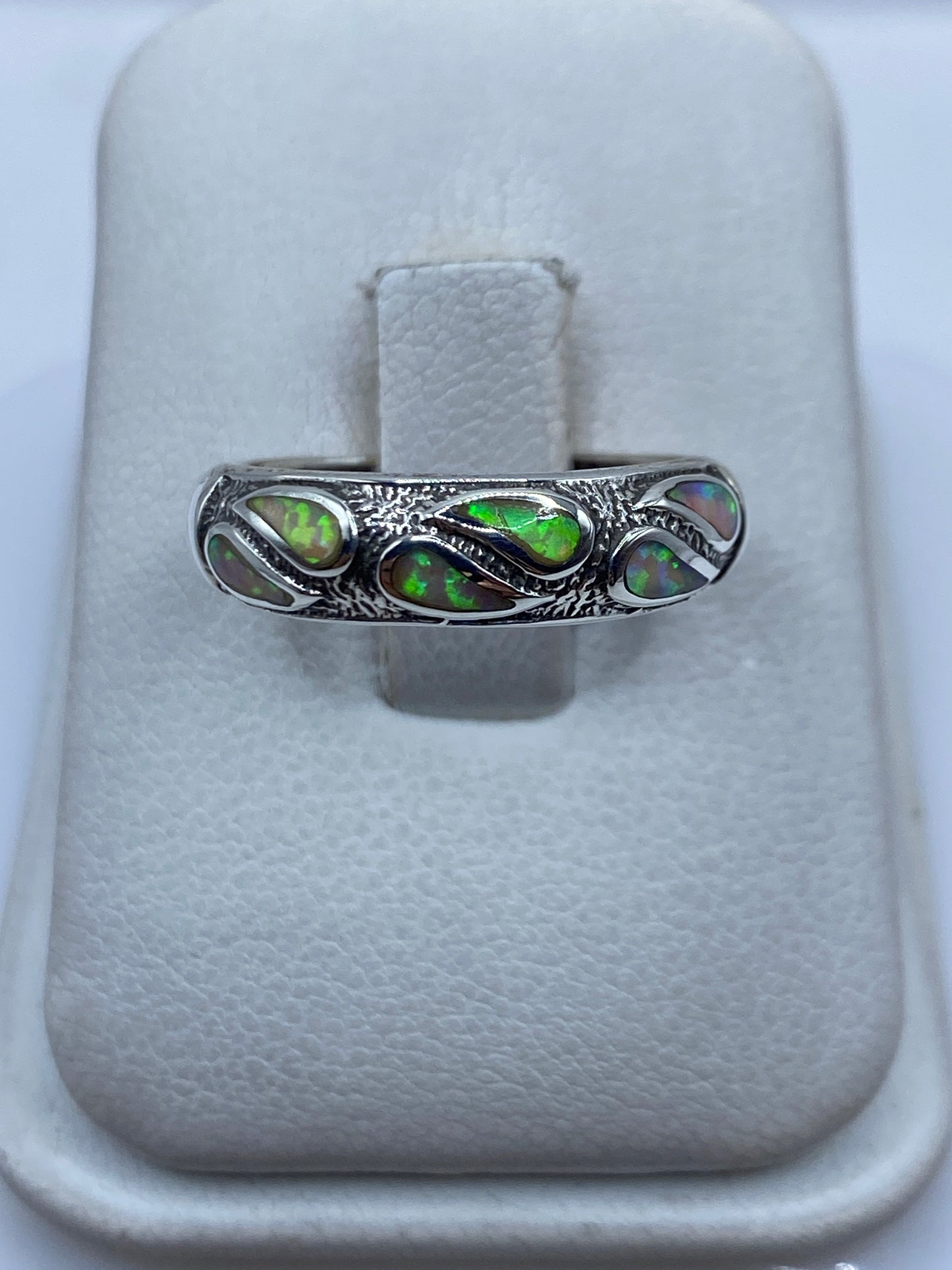 Anillo de plata .950 con ópalo de fuego multicolor en el dedo de una persona