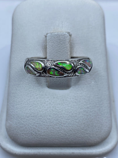 Anillo de plata .950 con ópalo de fuego multicolor en el dedo de una persona