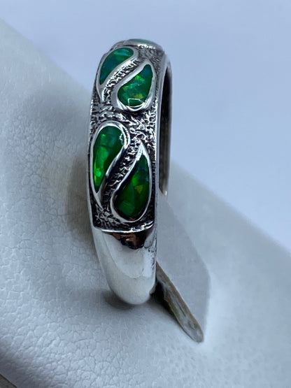 Anillo de ópalo de fuego en la mano mostrando el color verde limón con reflejos