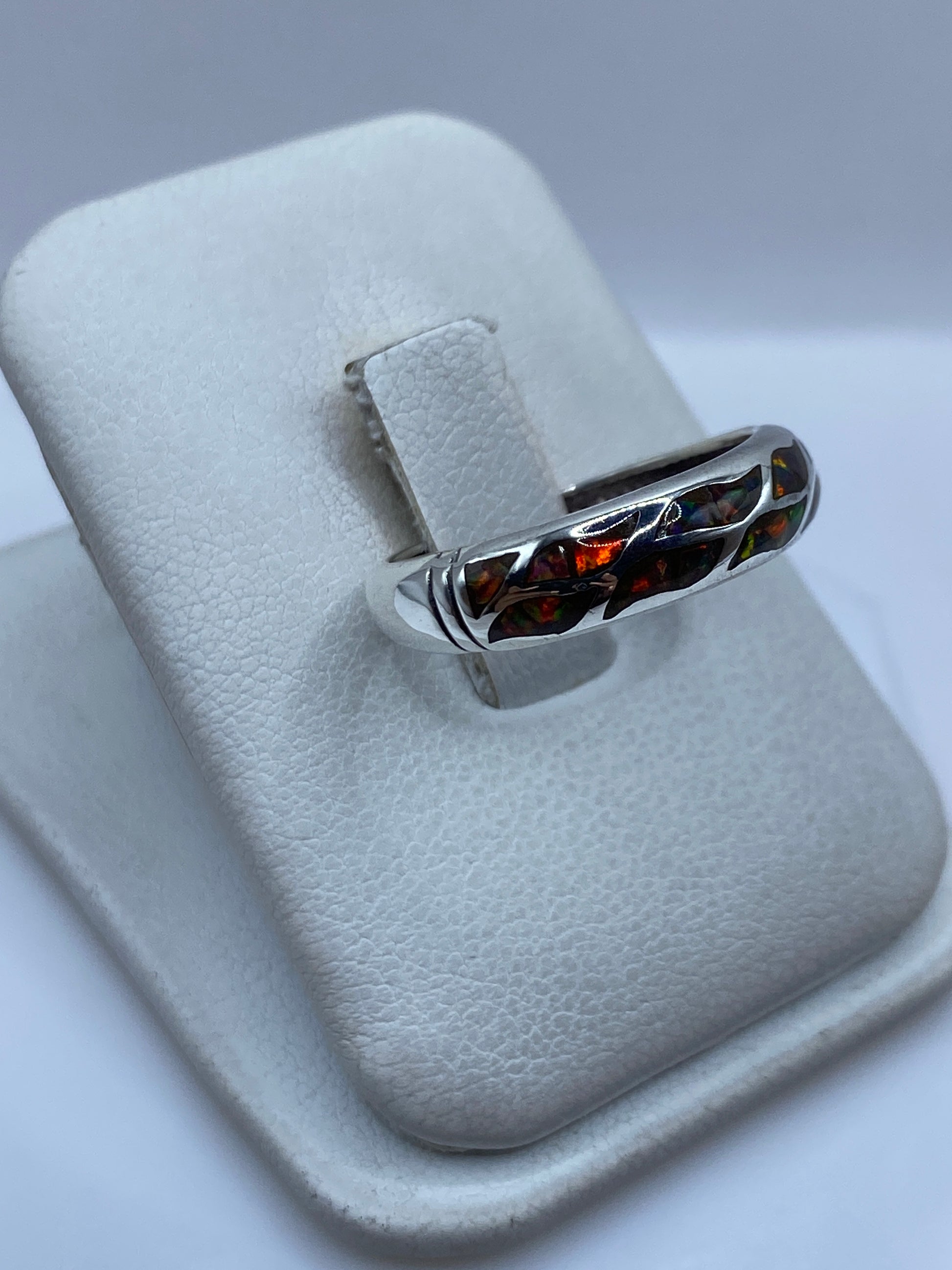 Vista lateral del anillo minimalista mostrando el ópalo de fuego rojo y naranja