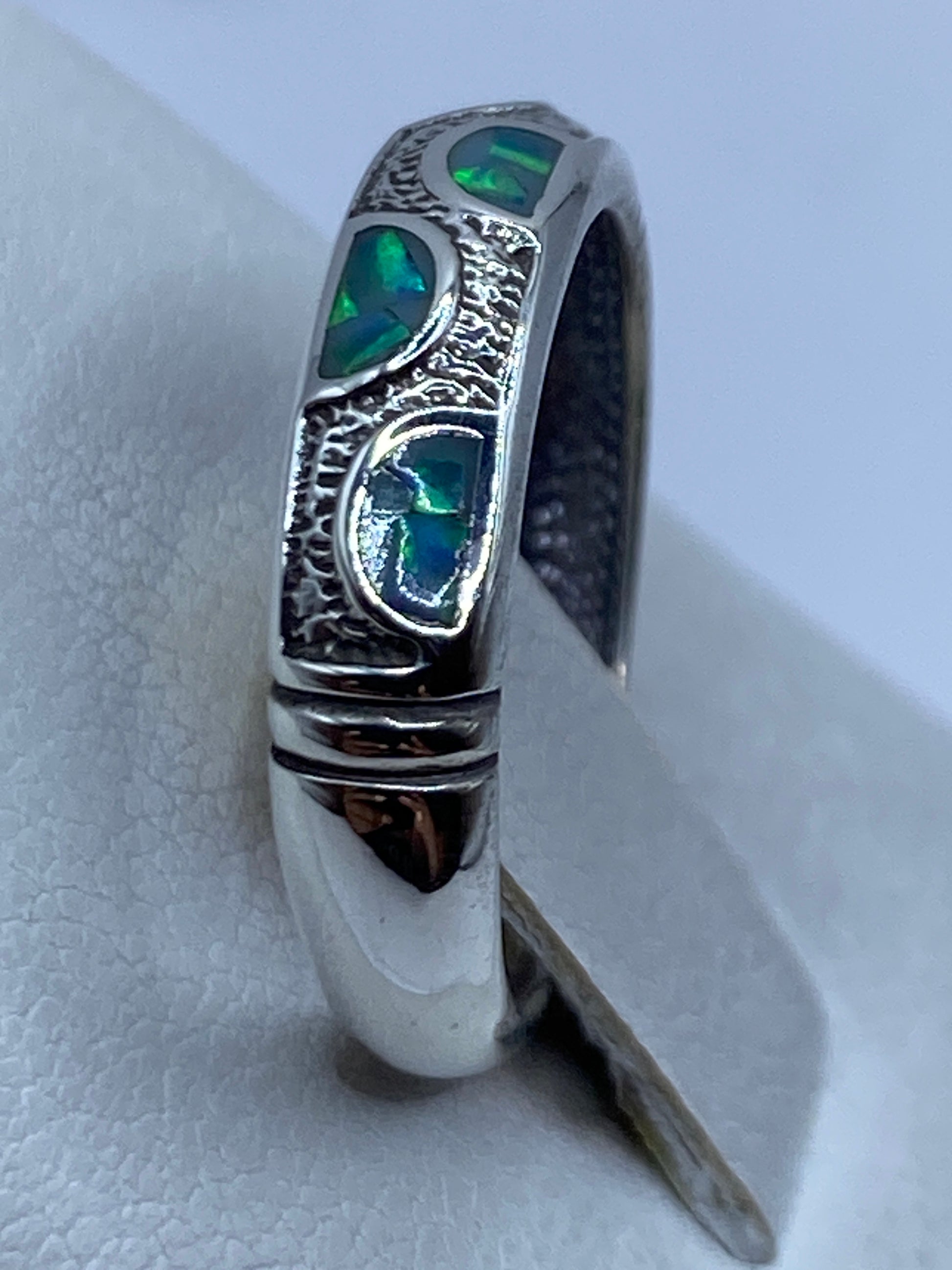 Anillo de plata .925 con ópalo azul verdoso en dedo, mostrando inclusiones de luz natural