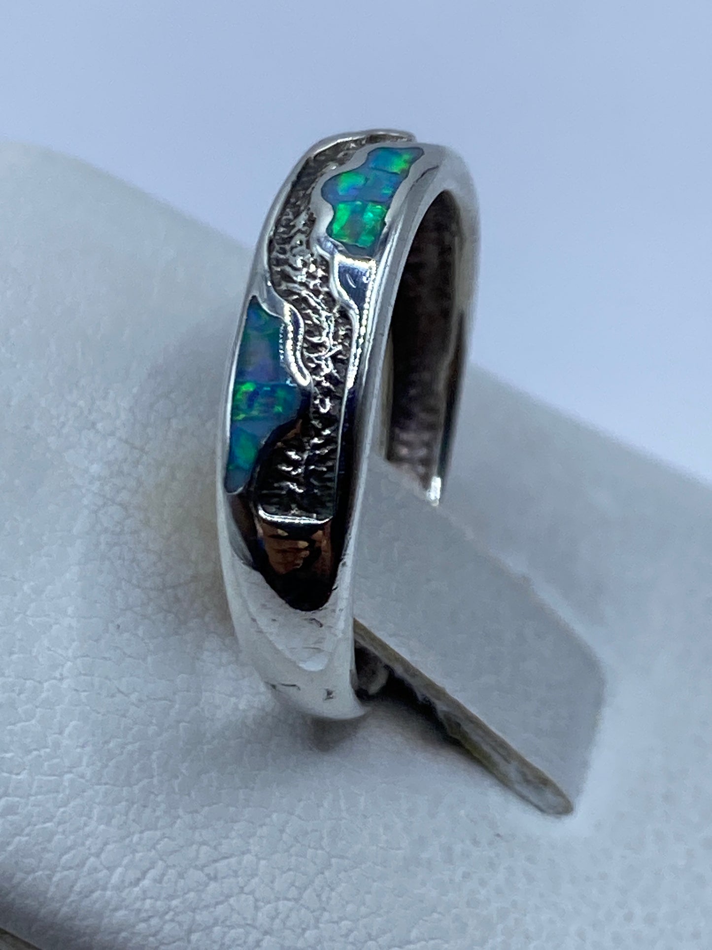 Anillo en la mano mostrando el color azul cielo del ópalo y el Quinto .950