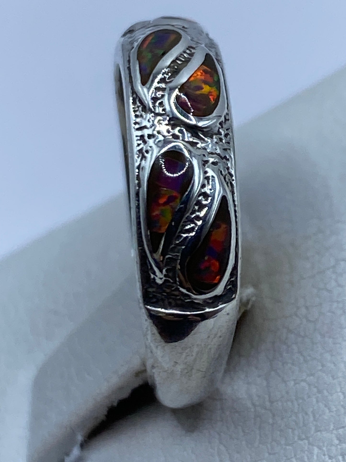 Anillo de plata con incrustación de piedra, vista lateral en dedo