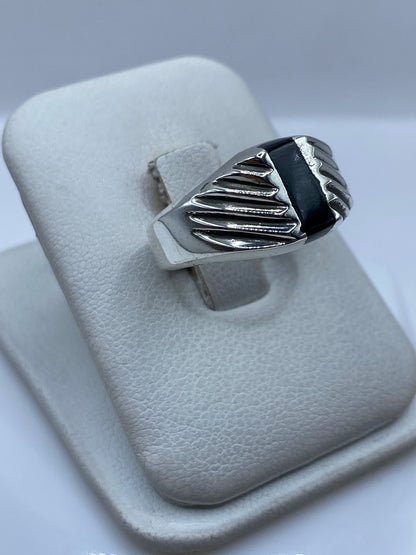 Vista lateral del anillo de plata con ónix negro, mostrando el engaste a mano