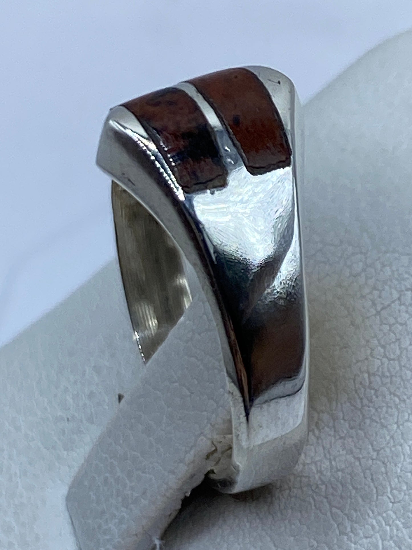Detalle del anillo en dedo, piedra cafe sobre plata .925