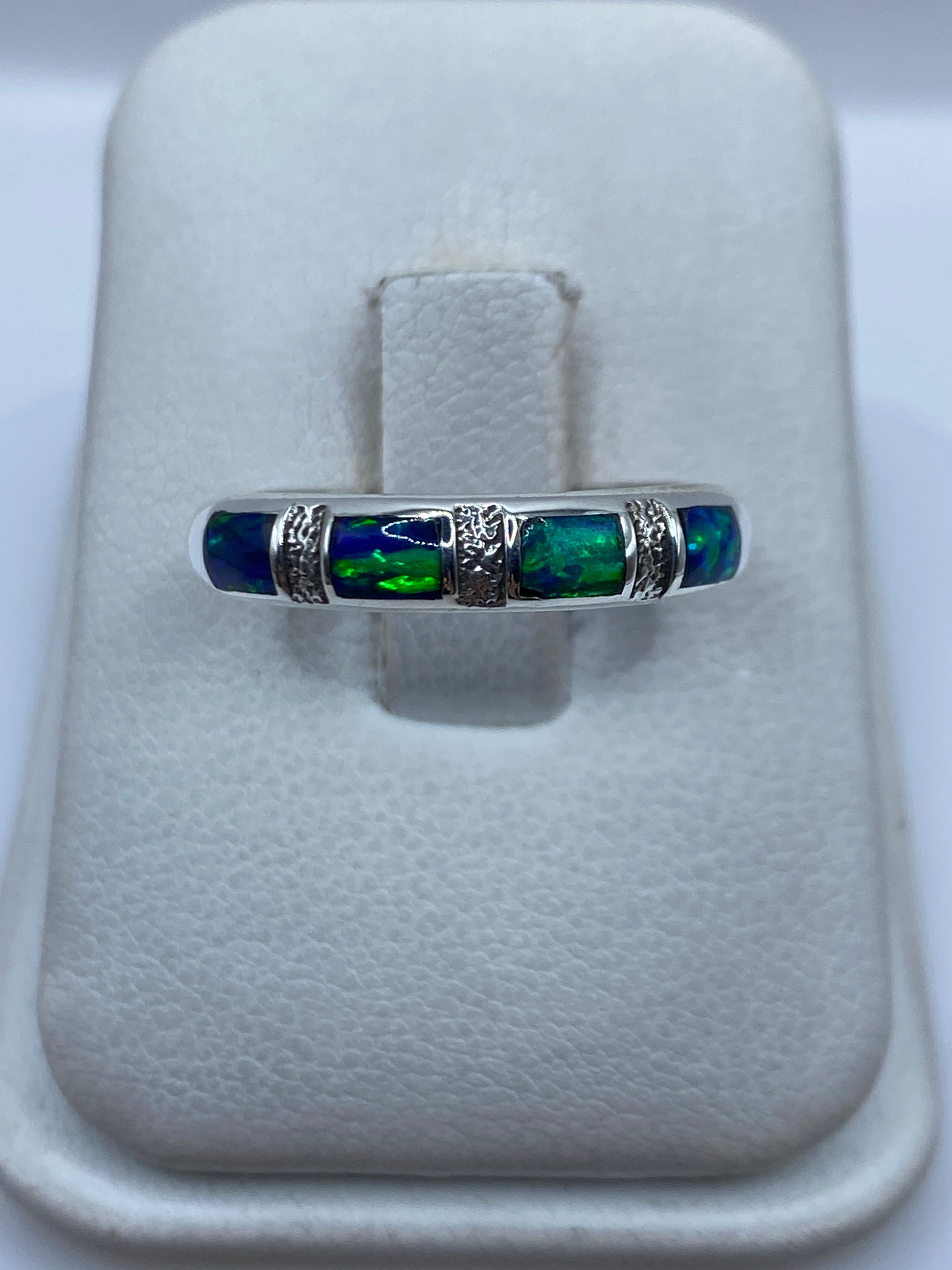 Anillo de plata .950 con ópalo de fuego azul engastado, visto de frente en la mano