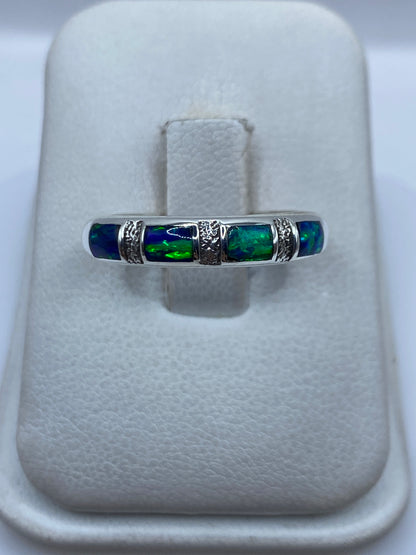 Anillo de plata .950 con ópalo de fuego azul engastado, visto de frente en la mano