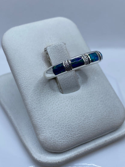 Detalle lateral del anillo mostrando el engaste de ópalo y el patrón de plata