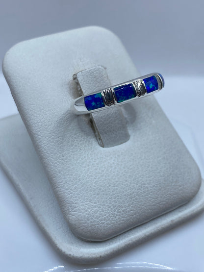 Detalle del ópalo de fuego azul engastado entre bandas de plata pura en la mano