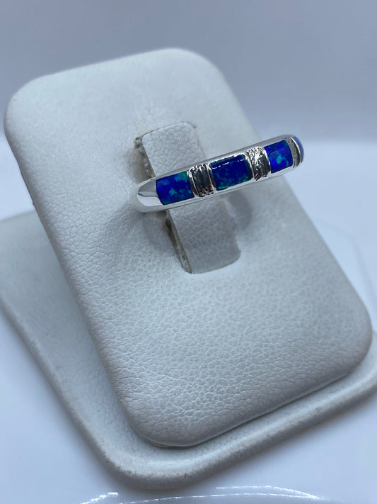 Detalle del ópalo de fuego azul engastado entre bandas de plata pura en la mano