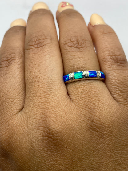 Anillo sobre fondo gris mostrando el Quinto .950 y los reflejos iridiscentes del ópalo