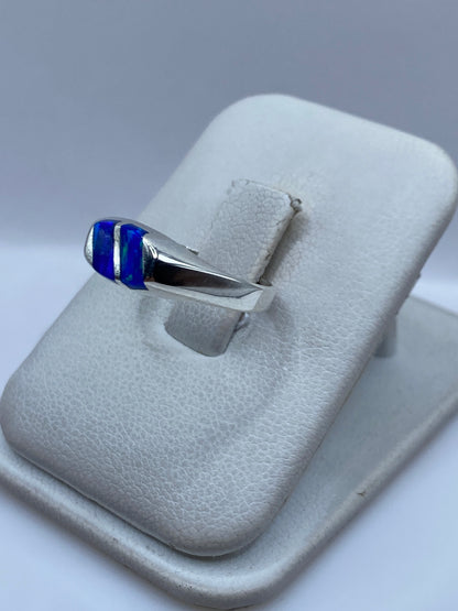Vista lateral del anillo minimalista de plata con ópalo azul engastado