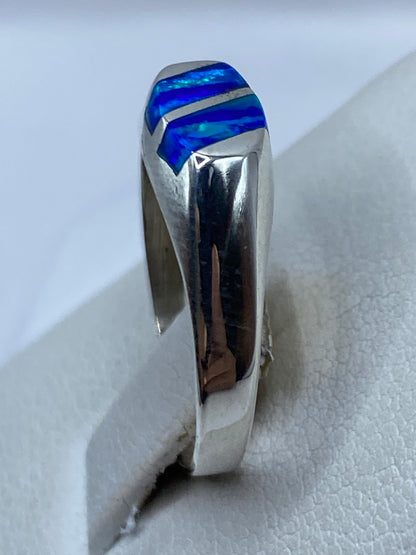Anillo de ópalo de fuego azul en dedo de mujer mostrando el fuego de la piedra