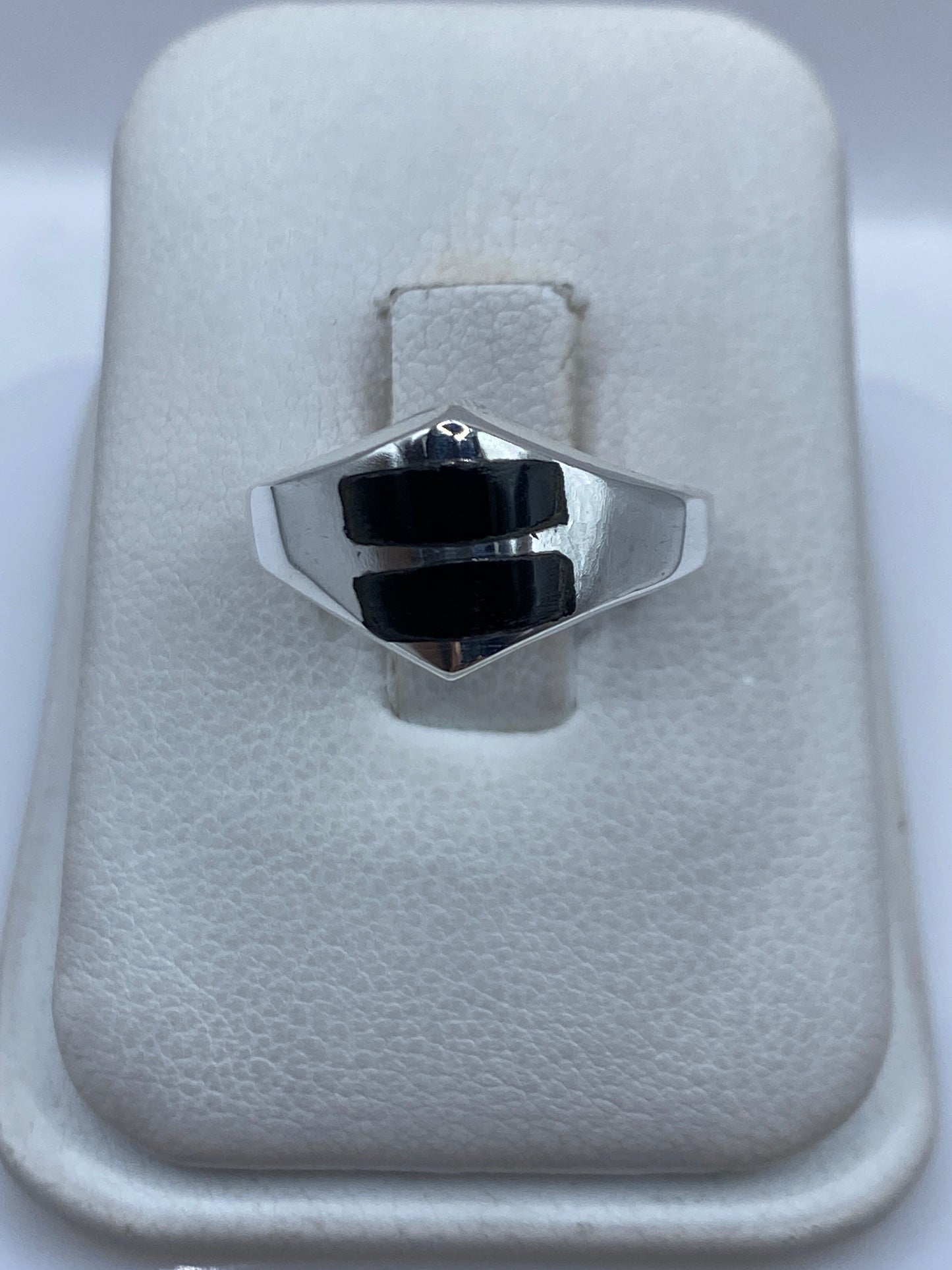 Anillo de plata con ónix negro en forma hexagonal sobre fondo blanco