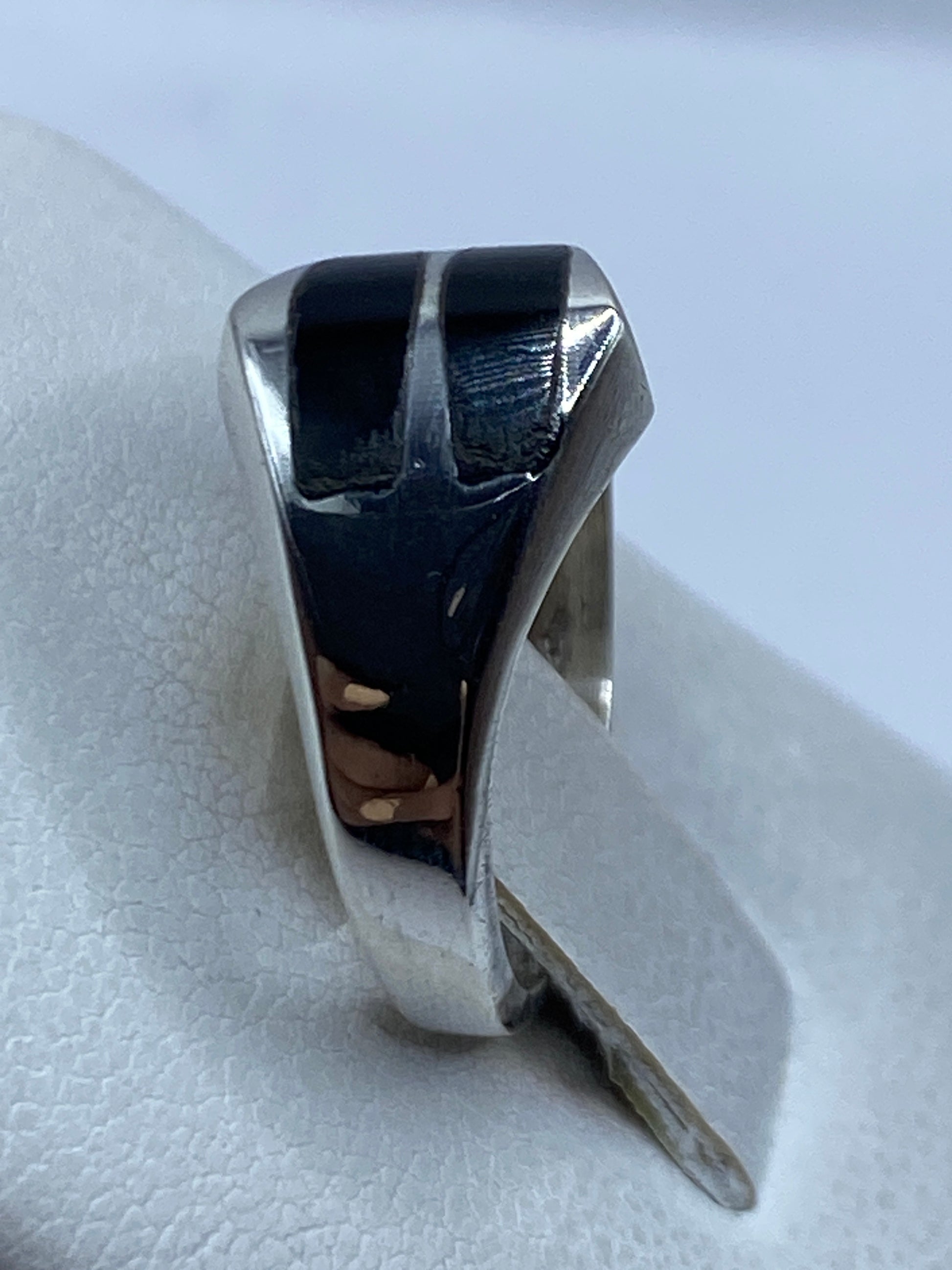 Detalle del ónix negro pulido y el engaste de plata en el anillo