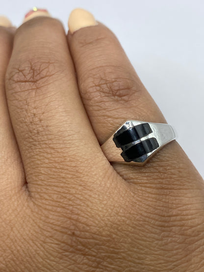 Anillo de plata con ónix negro en la mano de un hombre, estilo unisex