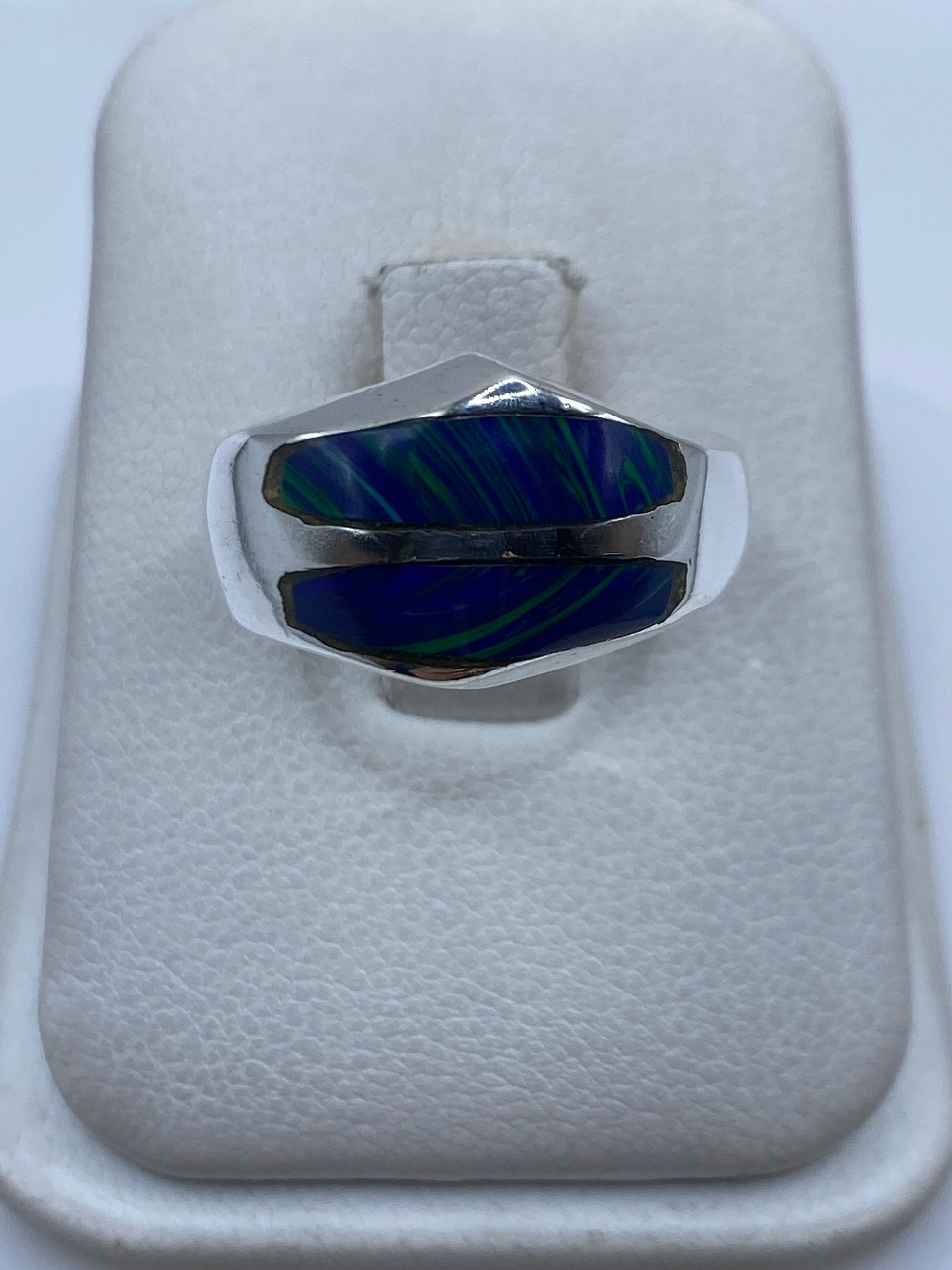 Anillo de plata con piedra azul engastada en diseño moderno, vista frontal