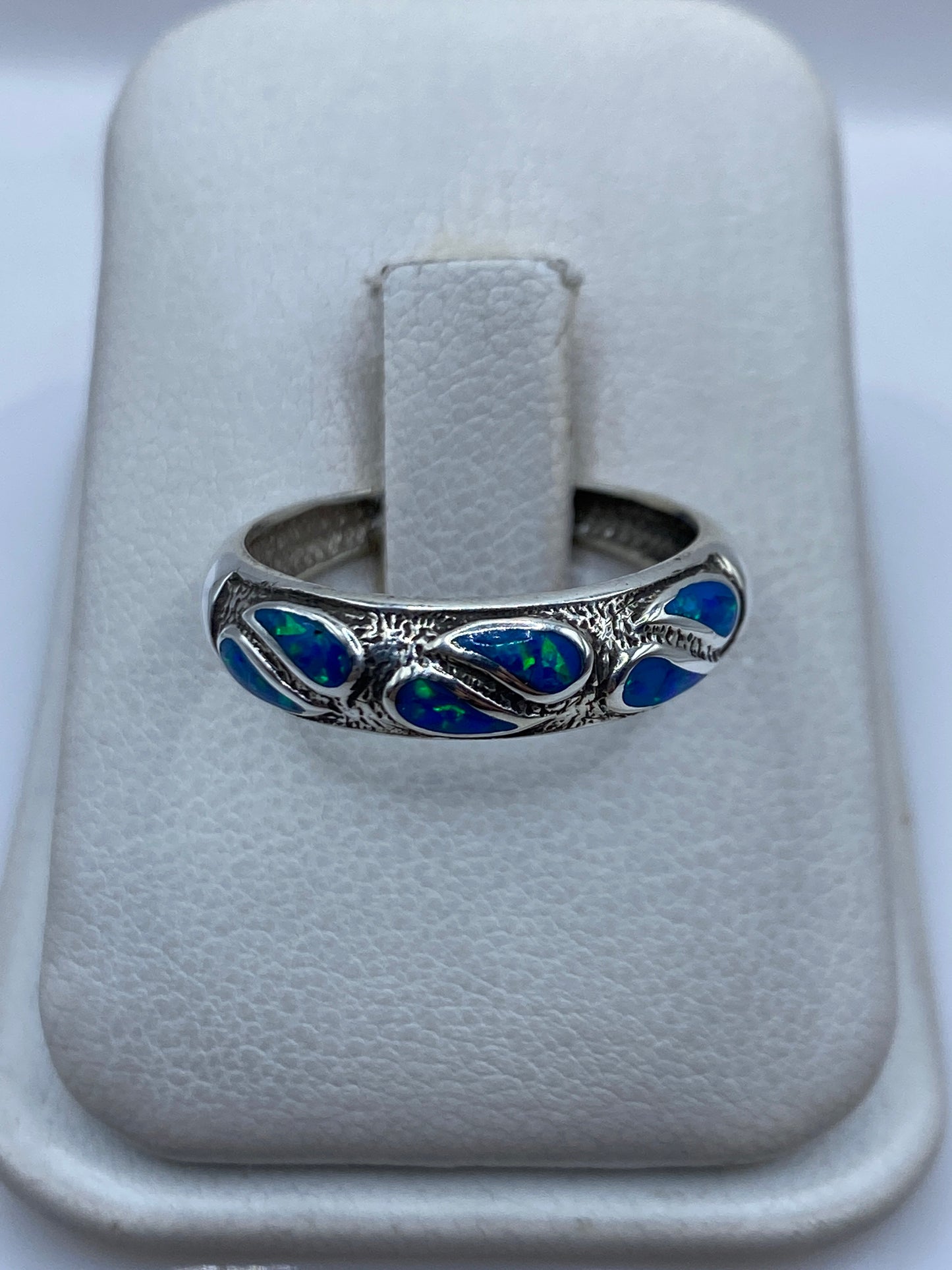 Anillo de plata .950 con ópalo de fuego azul engastado, sobre dedo de mujer