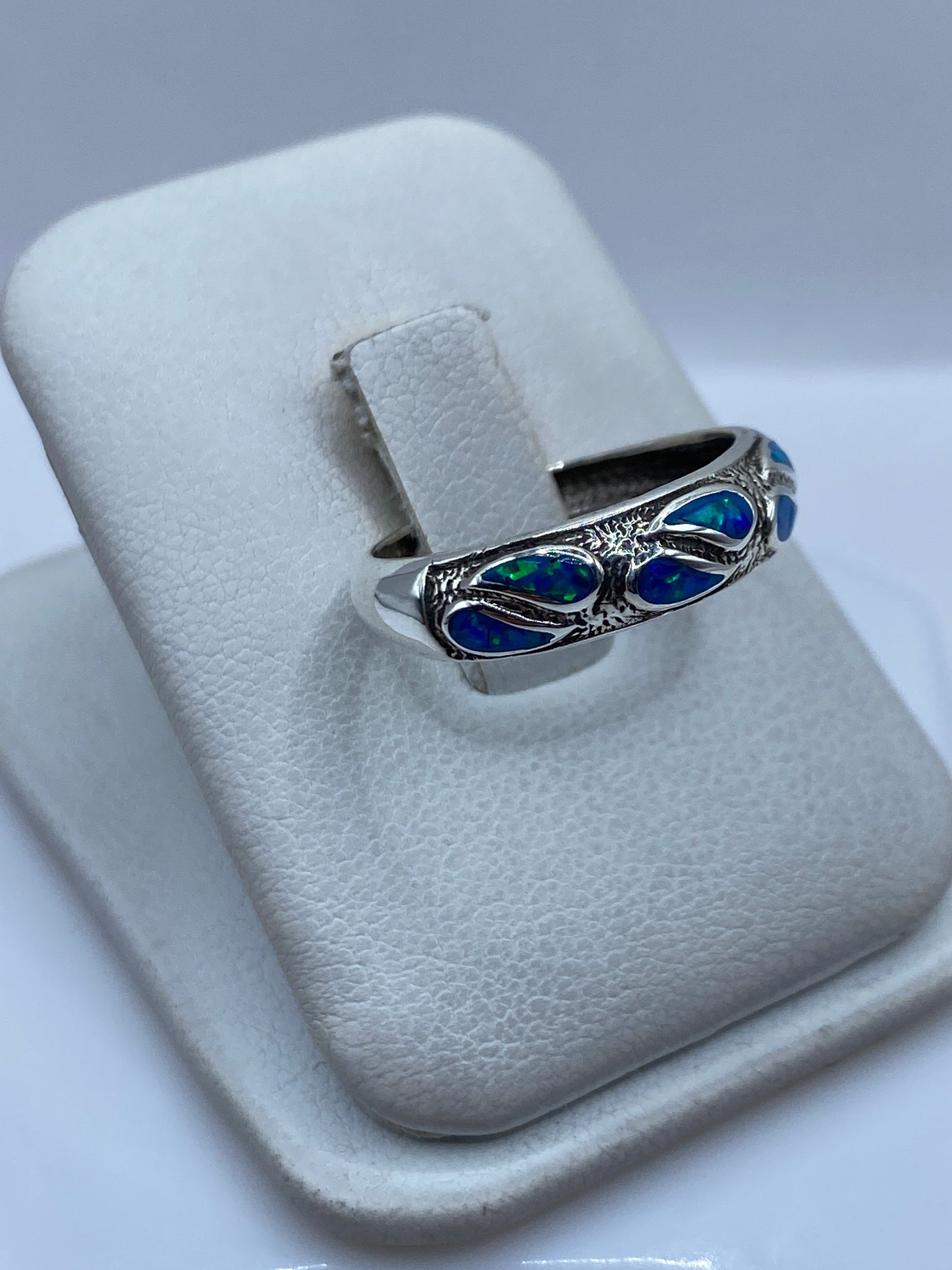 Vista superior del anillo mostrando el ópalo azul reflejante en engaste minimalista