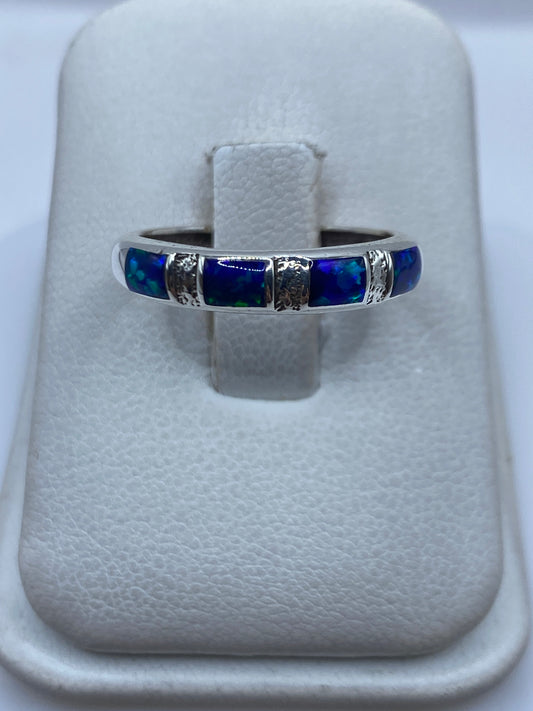 Anillo de plata .950 con ópalo de fuego iridiscente en mano