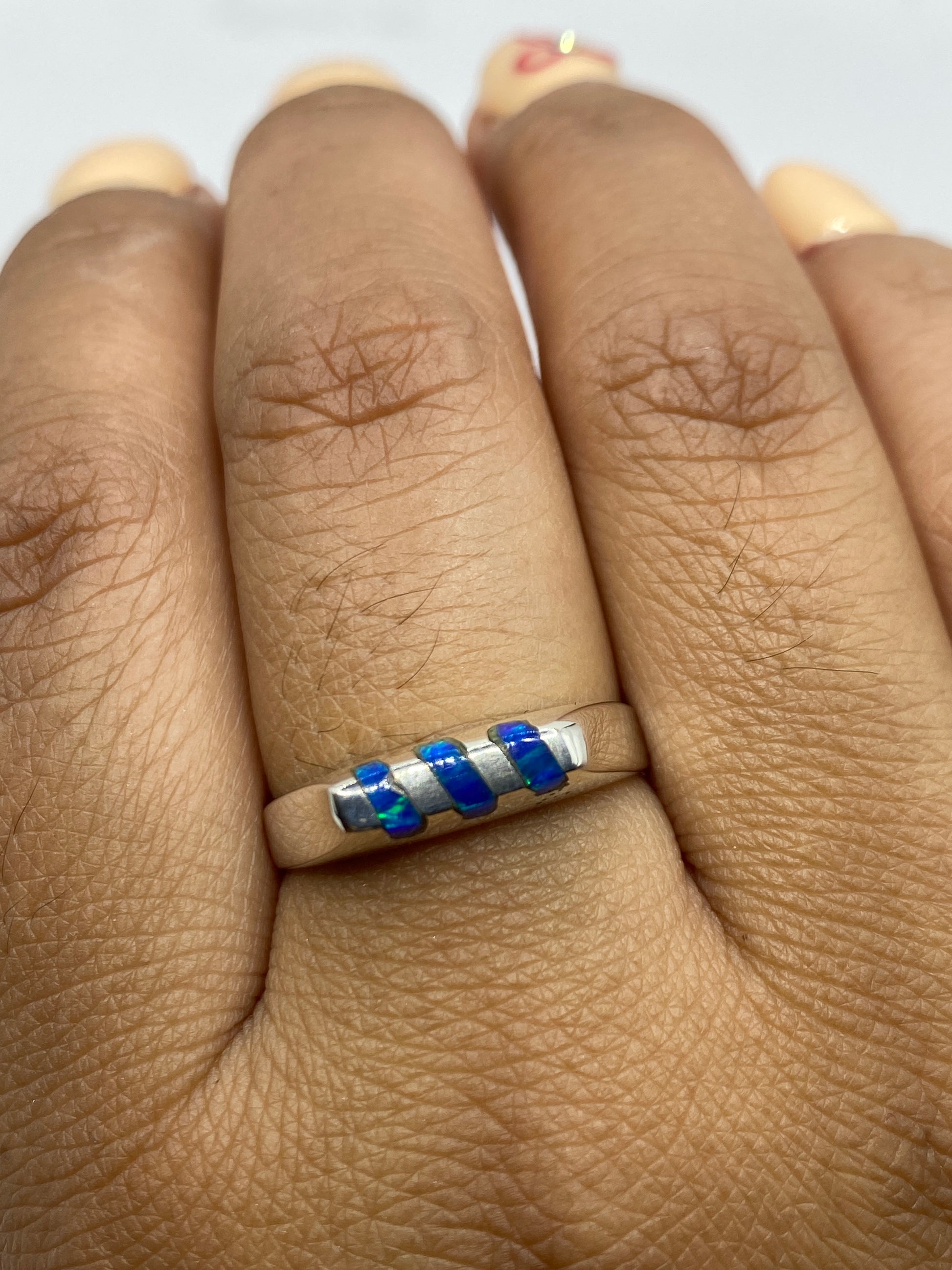 Anillo en dedo mostrando el brillo del ópalo y la plata pulida