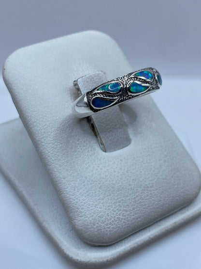 Detalle de la incrustación del ópalo de fuego mostrando el brillo y tonalidad azul