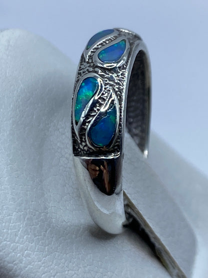 Anillo en la mano mostrando los reflejos del ópalo bajo luz natural