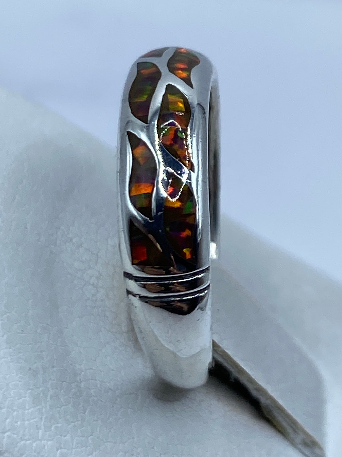 Anillo en la mano mostrando los juegos de luz del ópalo multicolor