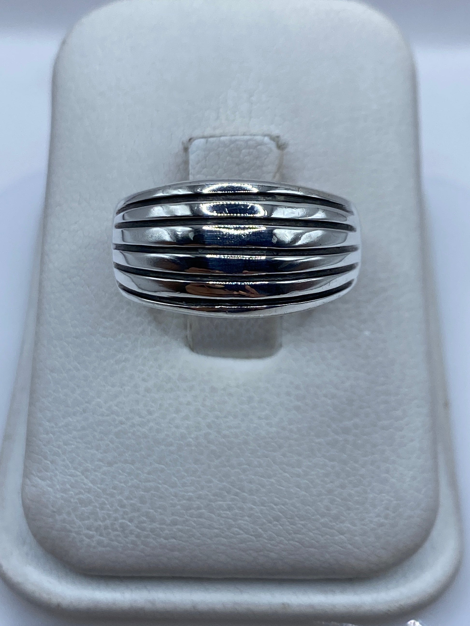 Anillo de plata con bandas paralelas pulidas sobre fondo blanco