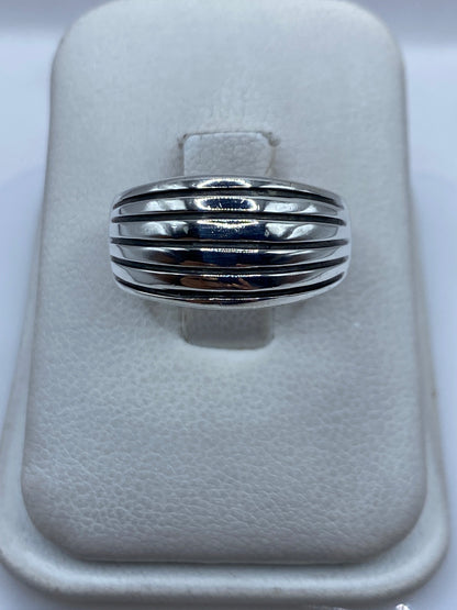 Anillo de plata con bandas paralelas pulidas sobre fondo blanco