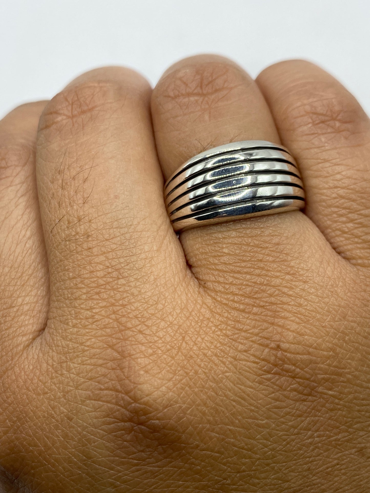 Anillo en mano mostrando el pulido espejo y el Quinto .925