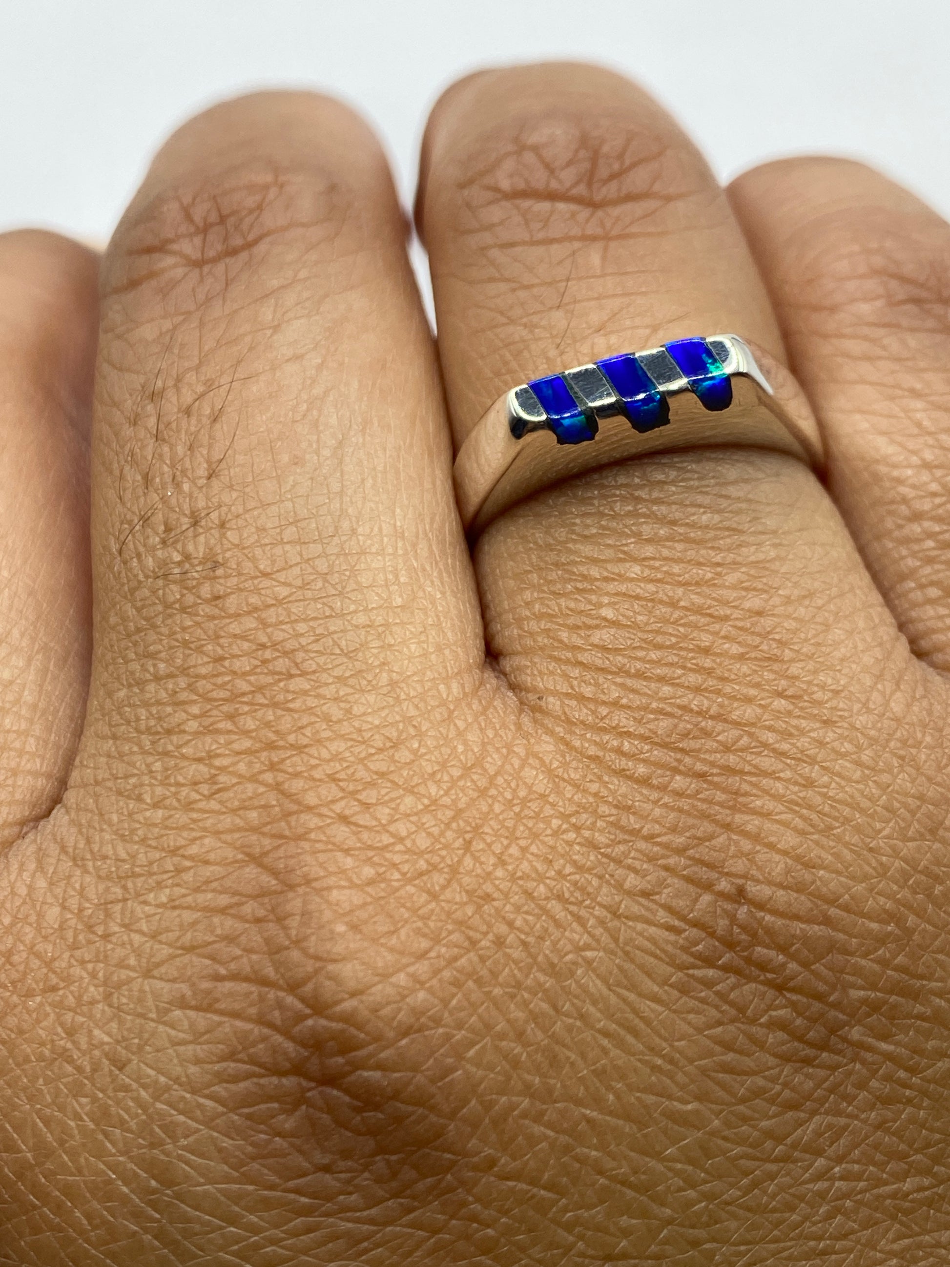 Anillo de plata en dedo mostrando el tono azul y el brillo natural del ópalo
