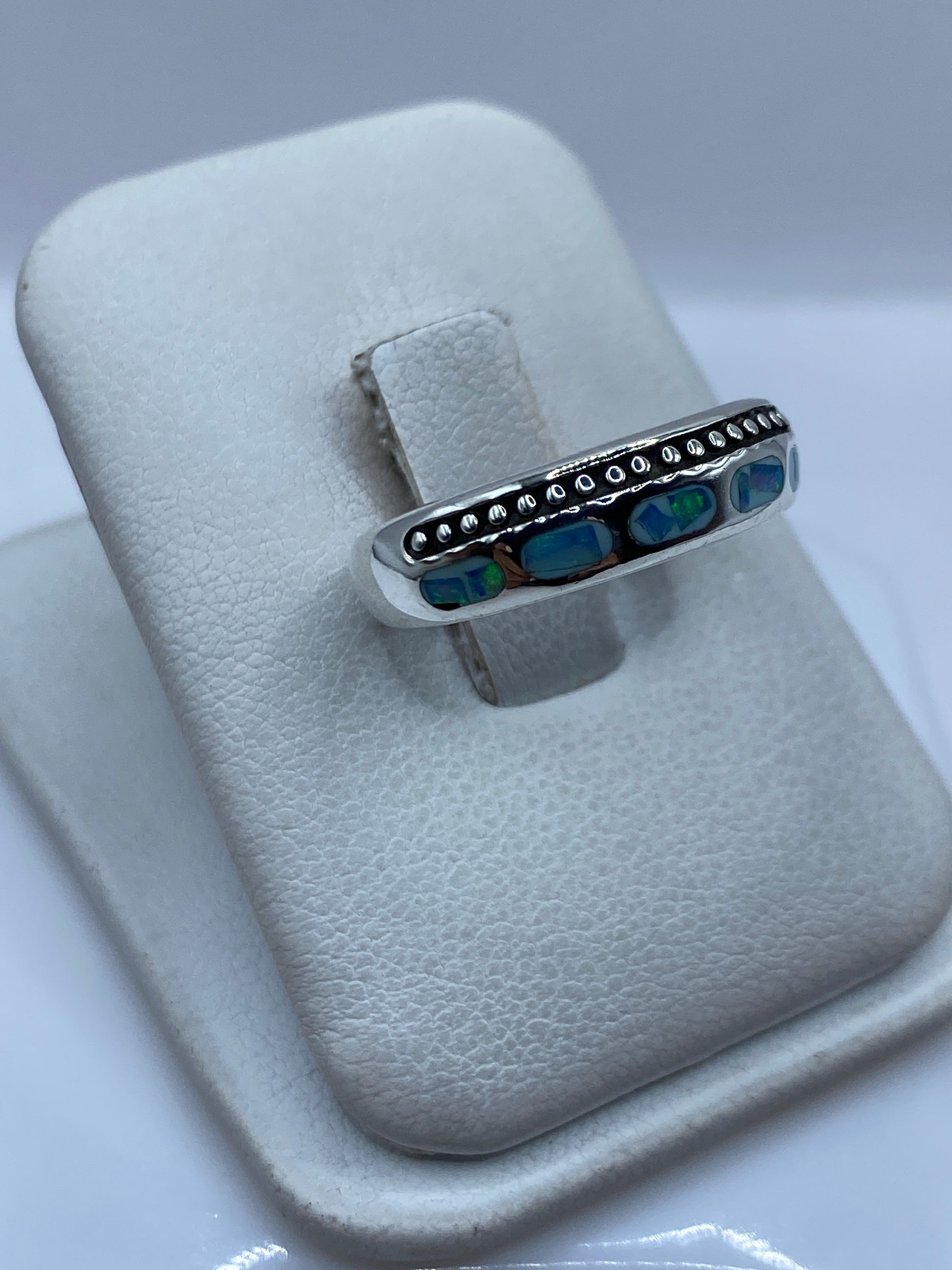 Vista frontal del anillo mostrando el ópalo de fuego con reflejos azules y verdes