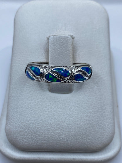 Anillo de plata .950 con ópalo de fuego azul engastado a mano, sobre estuche blanco