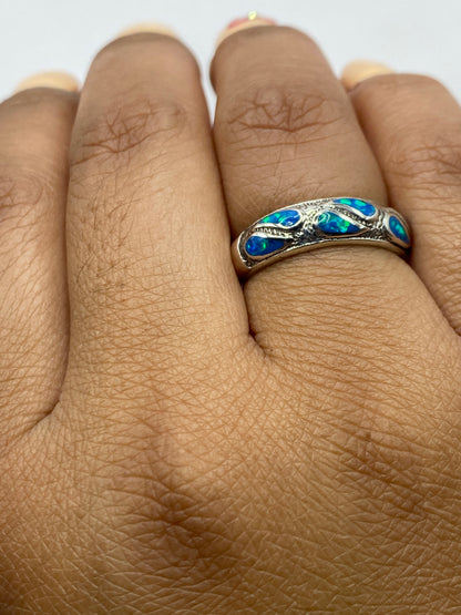 Anillo puesto en dedo mostrando el brillo del ópalo de fuego azul