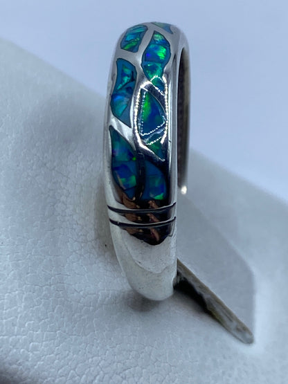 Anillo de plata ópalo fuego azul en la mano de un hombre