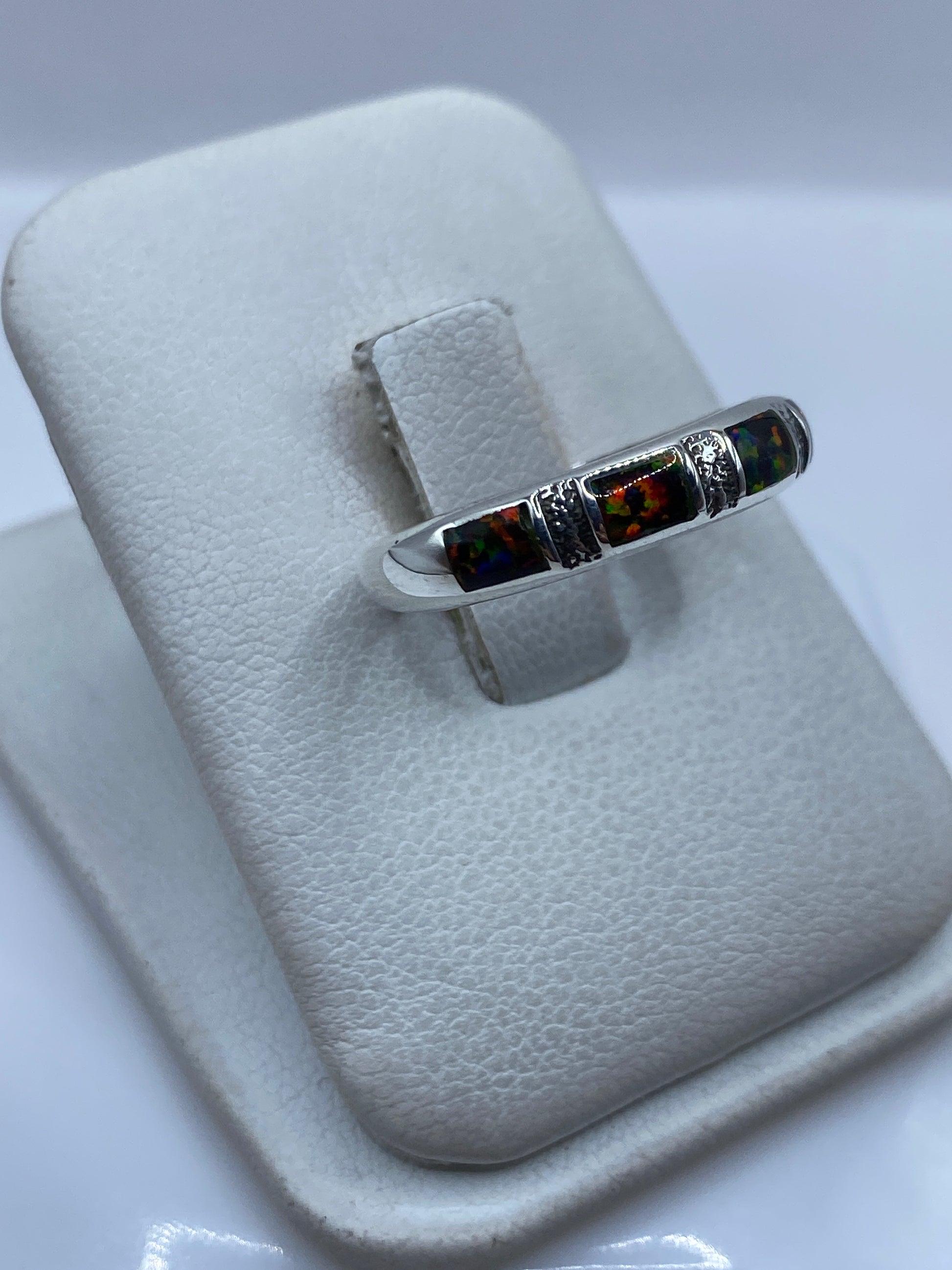 Detalle del engaste a mano del ópalo de fuego con reflejos rojo, naranja y verde