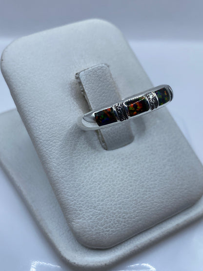 Detalle del engaste a mano del ópalo de fuego con reflejos rojo, naranja y verde