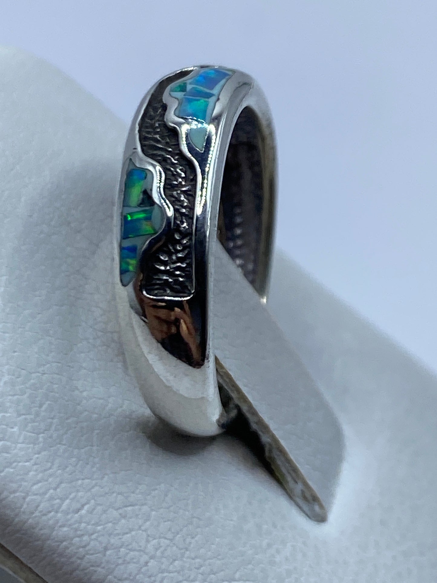 Anillo puesto en la mano mostrando el brillo azul del ópalo de fuego