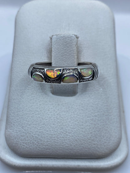 Anillo de plata con Opalo de Fuego multicolor engastado a mano, vista frontal en joyero blanco