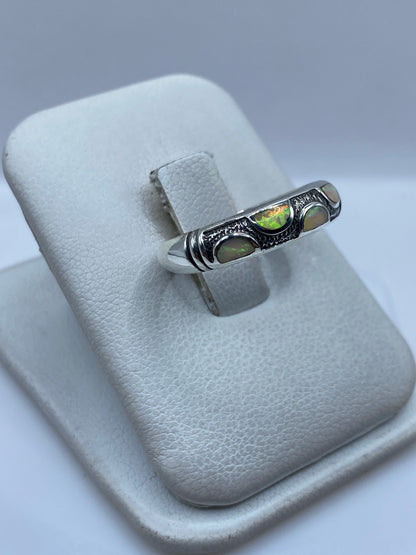 Detalle lateral del anillo mostrando el Opalo de Fuego con destellos verdes y dorados