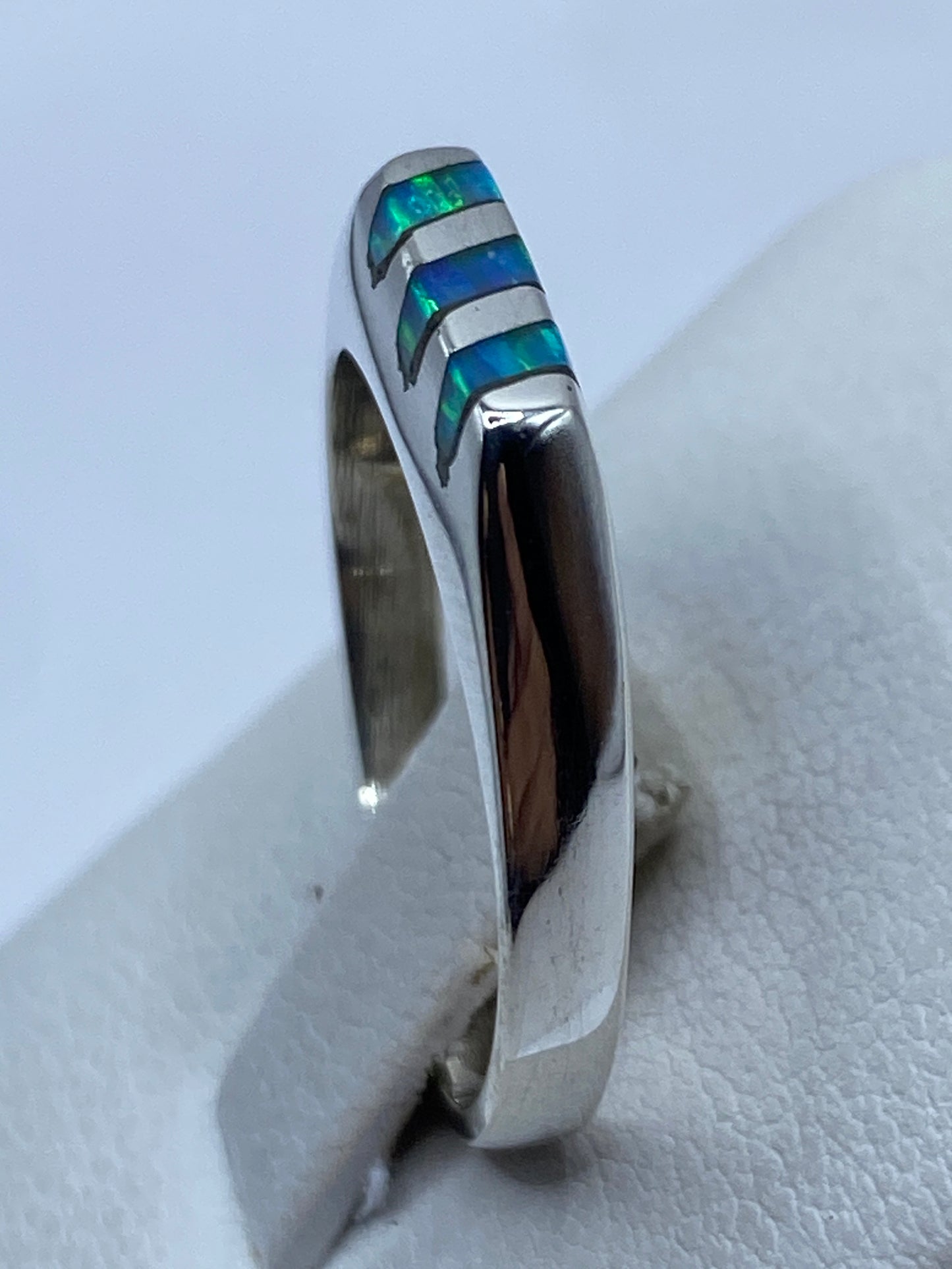 Anillo en dedo mostrando el color azul cielo y los reflejos iridiscentes del ópalo