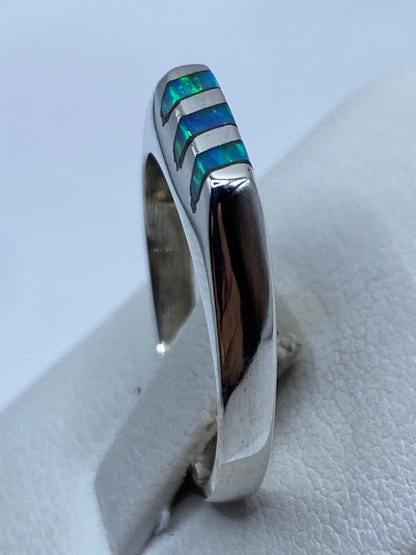 Anillo en dedo mostrando el color azul cielo y los reflejos iridiscentes del ópalo