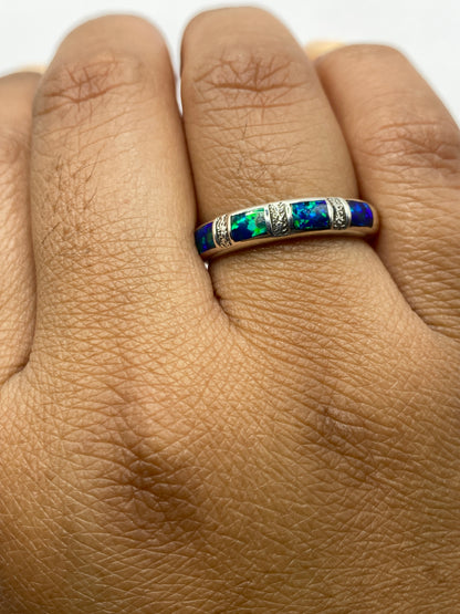 Anillo sobre fondo neutro exhibiendo los tonos azules y verdes del Ópalo de Fuego