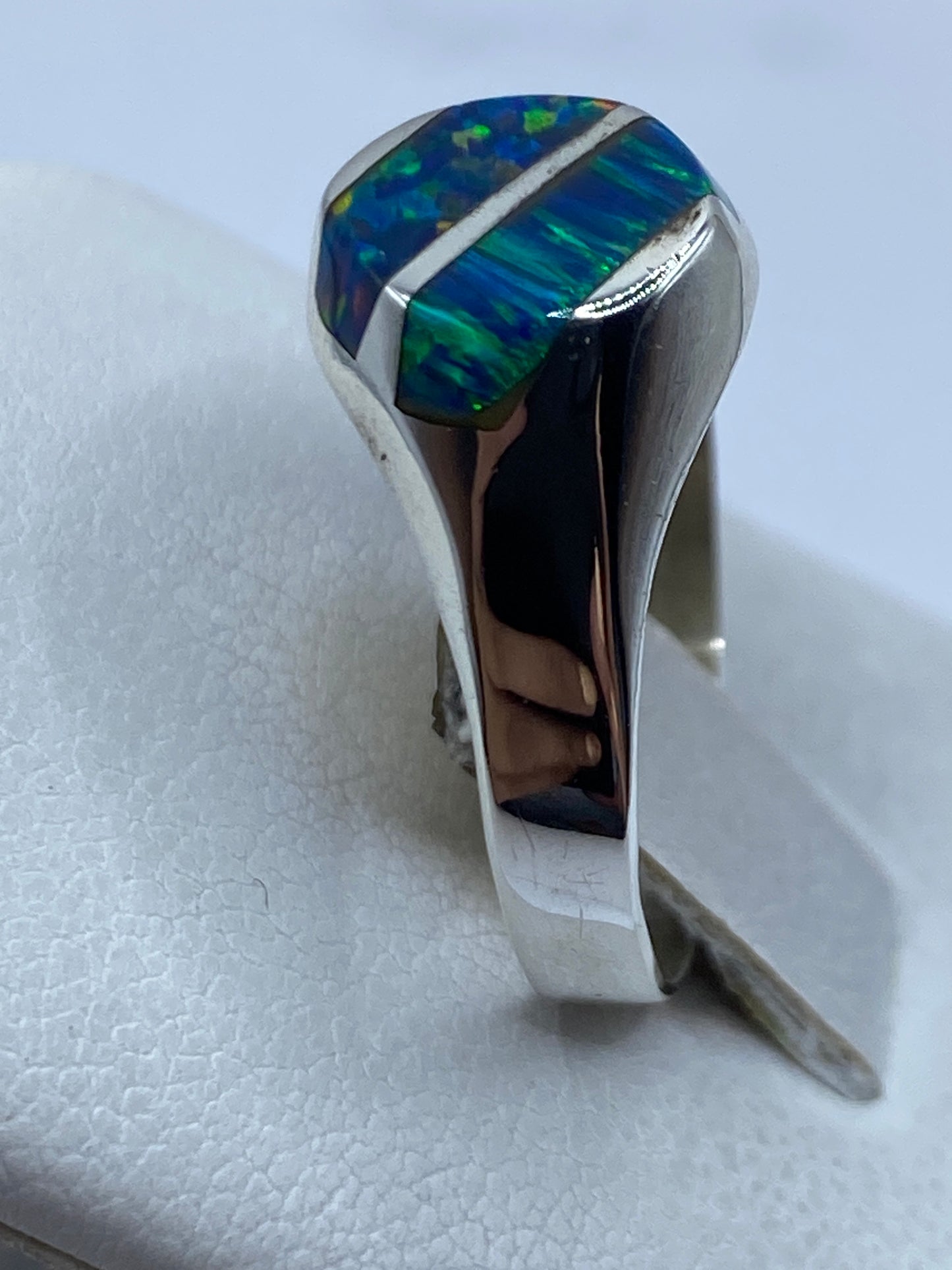 Anillo en la mano mostrando el tono azul profundo del ópalo de fuego