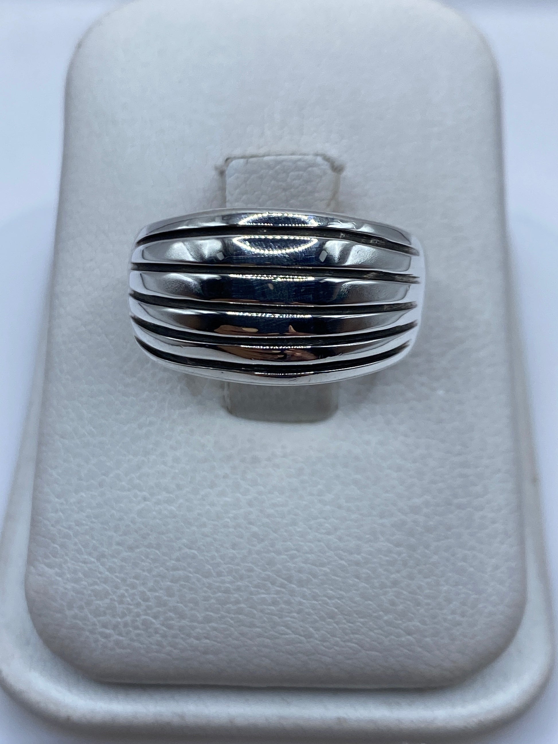 Anillo de plata con bandas paralelas pulidas en la mano de una mujer